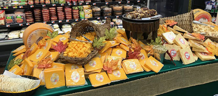 Large Table set up with variety of cheeses in a grocery store